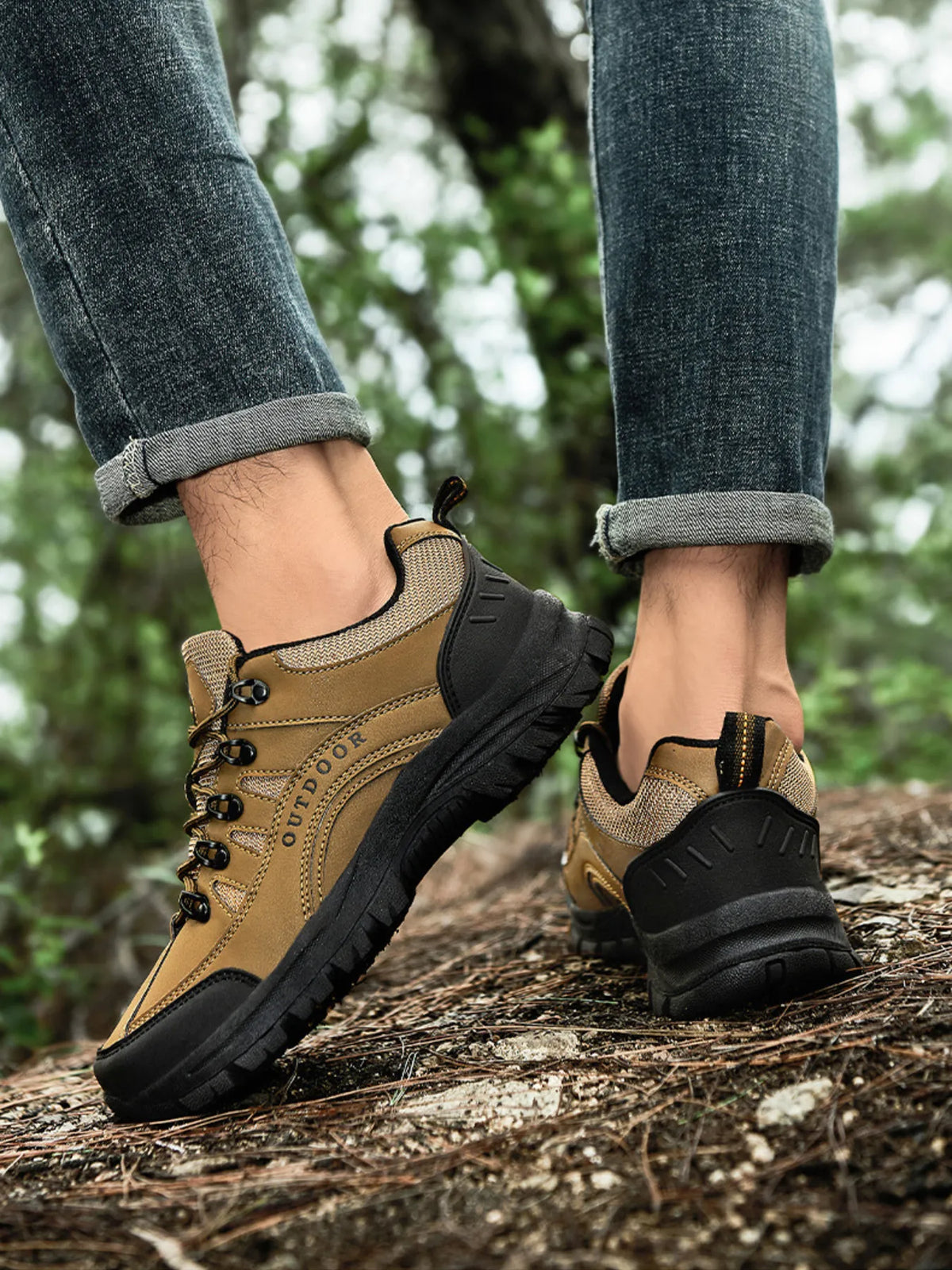 Tan and black low-top lace-up shoes with chunky treaded soles, worn on a log