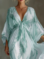 Close view of the mint feather-print maxi dress showing the front tie and draped sleeves.