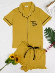 Mustard lounge set laid flat with black-piped button shirt and ruffle shorts