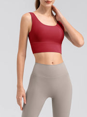 Model wearing the red scoop-neck tank with leggings, front view