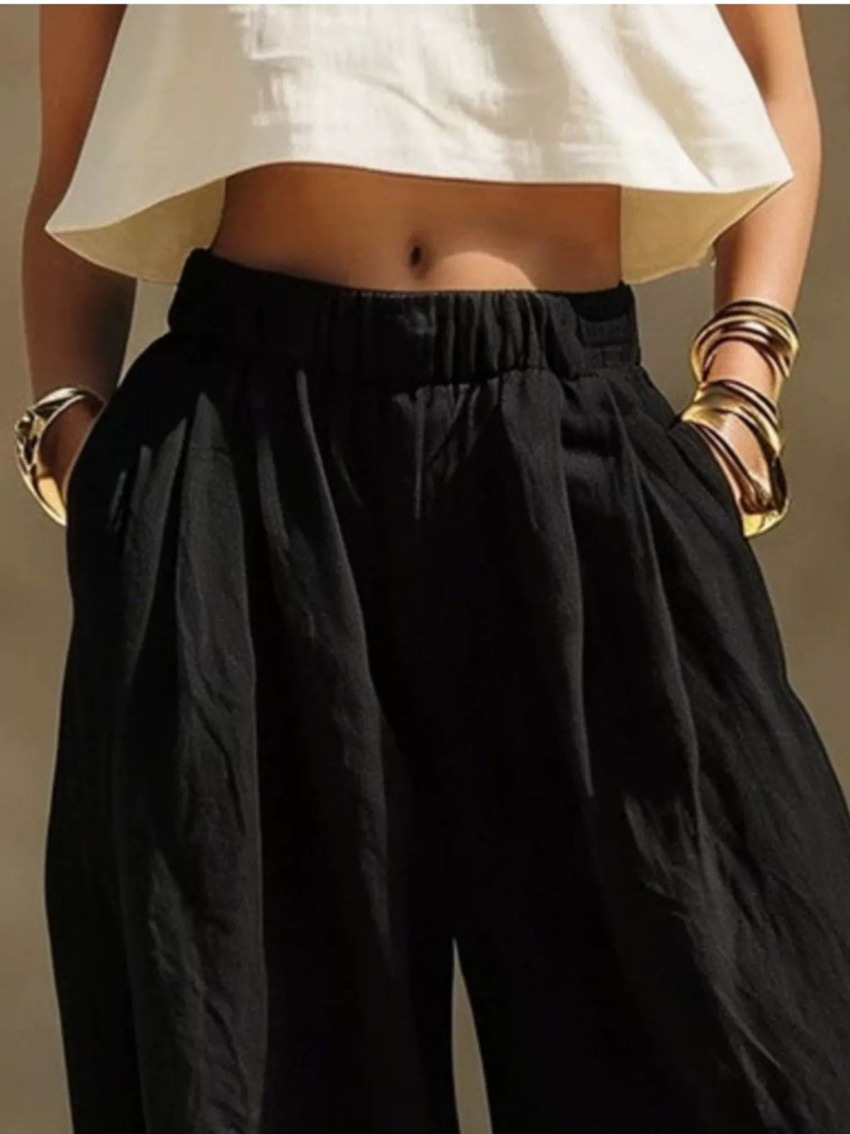 Front detail of black wide-leg pants with hands in side pockets