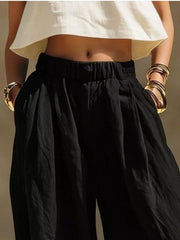 Front detail of black wide-leg pants with hands in side pockets