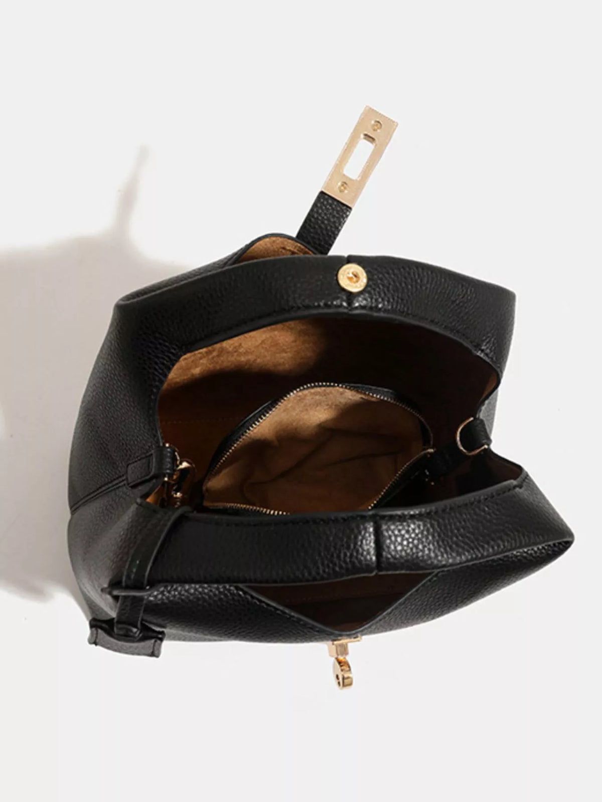 Open black handbag showing brown interior lining and inner zip compartment