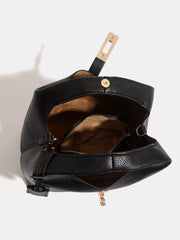 Open black handbag showing brown interior lining and inner zip compartment