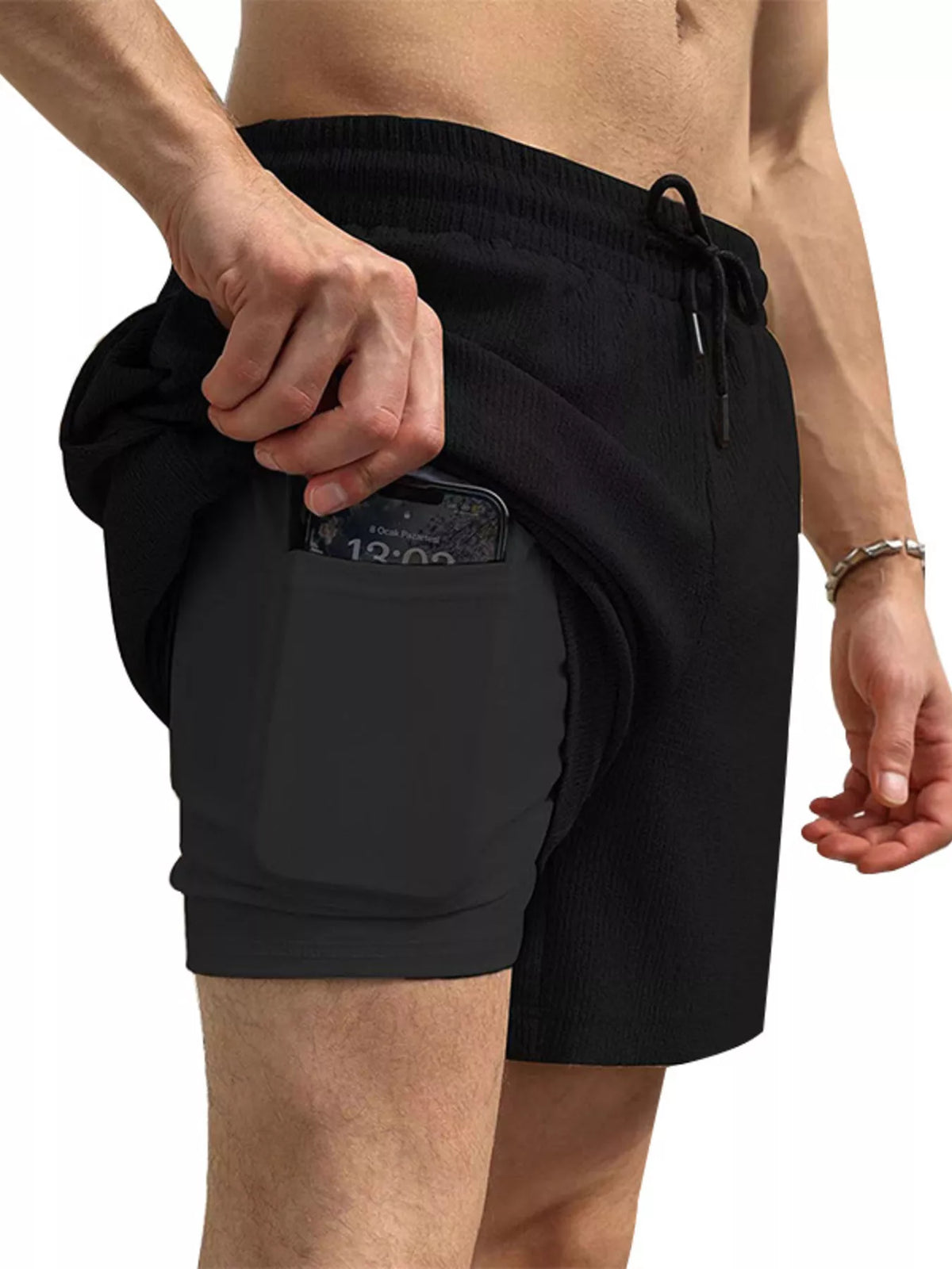 Model wearing black drawstring shorts, side view
