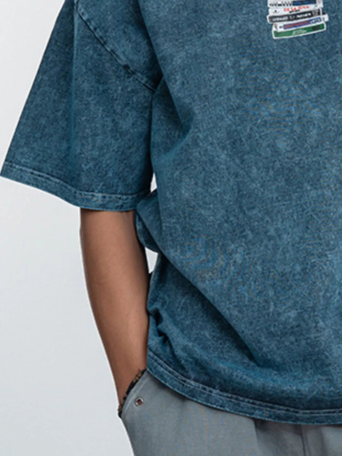 Close-up of the chest graphic and sleeve on the blue vintage-wash T-shirt