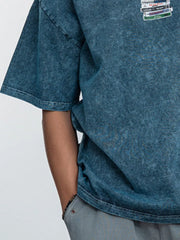 Close-up of the chest graphic and sleeve on the blue vintage-wash T-shirt