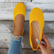 Yellow mesh flat held to show its perforated upper and insole