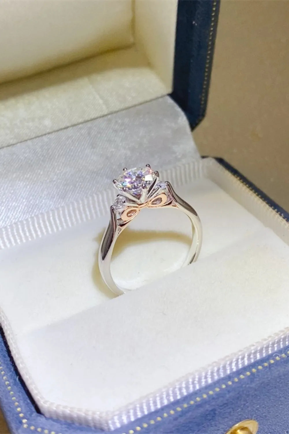 Side angle of a purple-stone ring showing its raised setting in a ring box