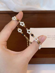 Close-up of alternating dark stone and pearl beads on the bracelet