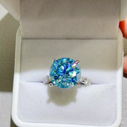 Front view of blue-green round stone ring in its box