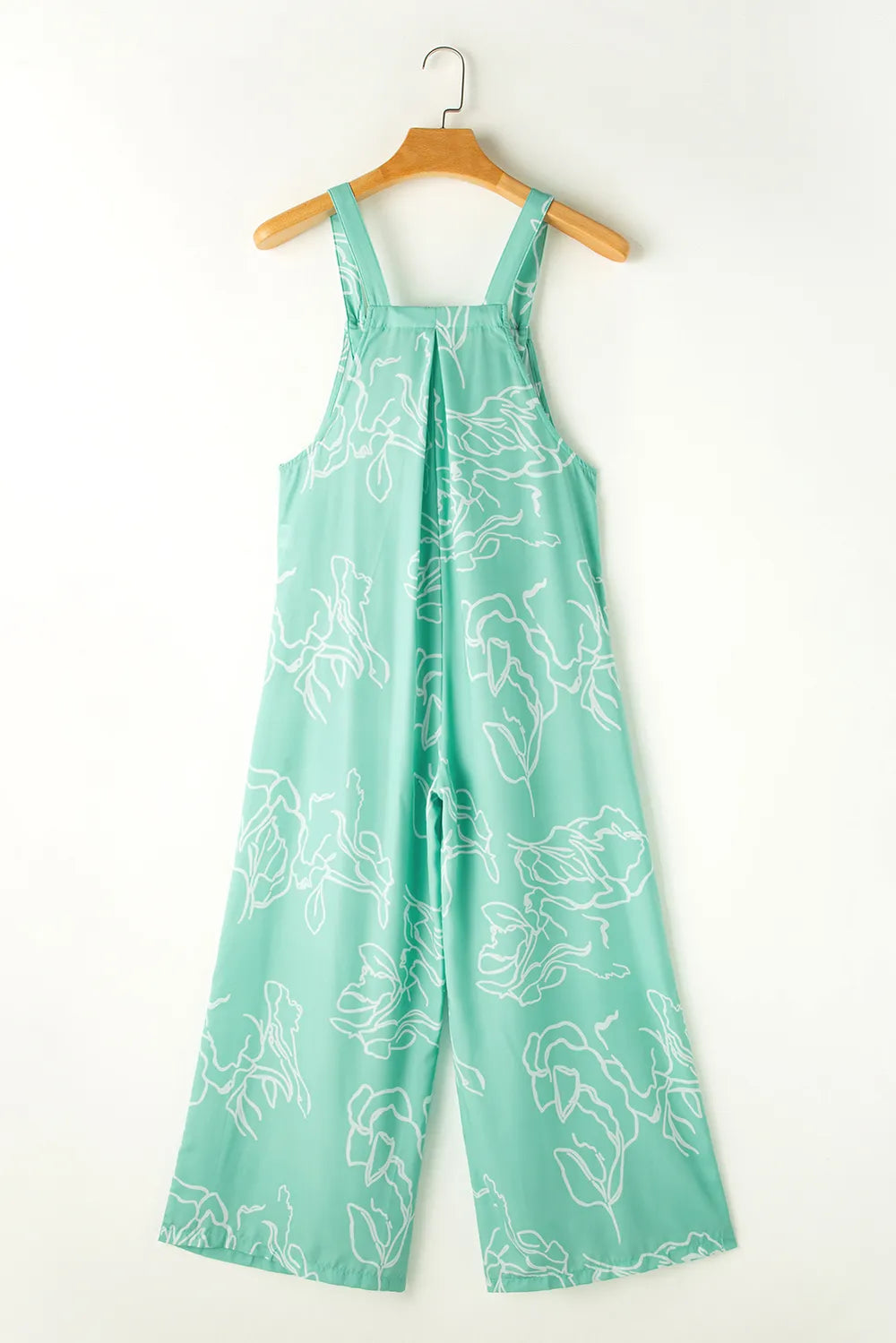 Back view of turquoise printed jumpsuit on hanger