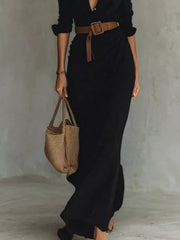 Lower view of the black maxi dress showing its long skirt and brown belt.