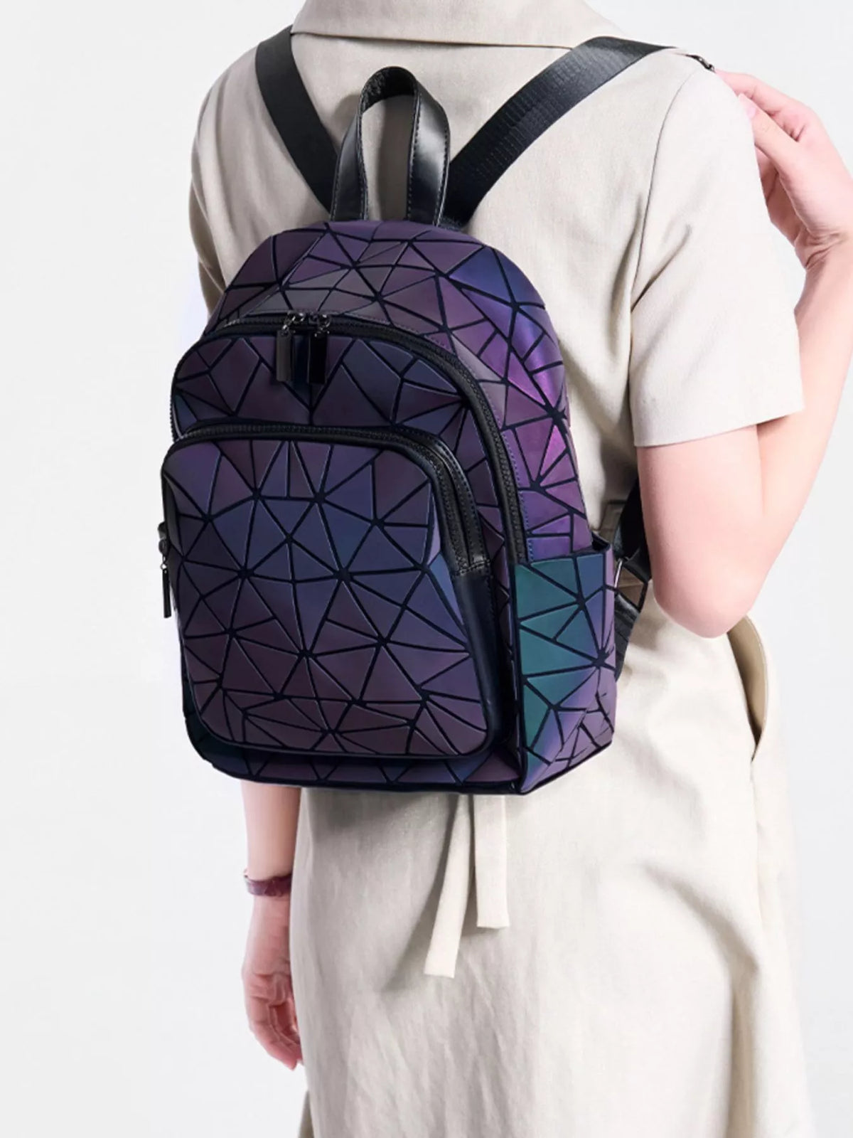 Geometric backpack with iridescent purple and blue panels worn on a model