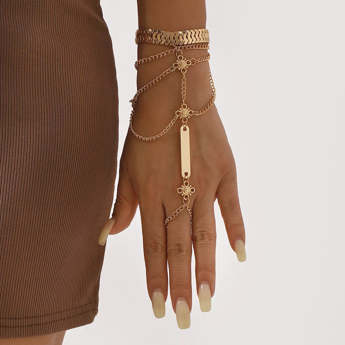 Gold-tone layered hand chain bracelet shown on a hand