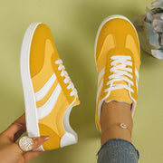 Pair of yellow flats with white stripes viewed from above