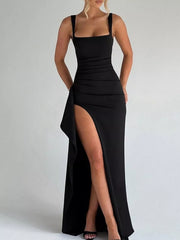 Front view of the black ruched maxi dress with a high side slit and ruffle detail.