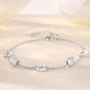Silver geometric chain bracelet with circular and rectangular accents displayed flat