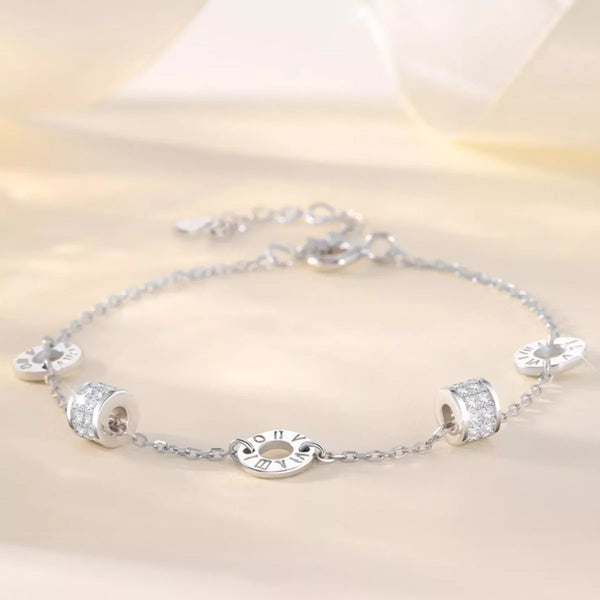 Silver geometric chain bracelet with circular and rectangular accents displayed flat