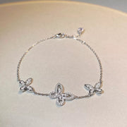 Silver-tone chain bracelet with three butterfly-shaped clear-stone accents arranged in an oval