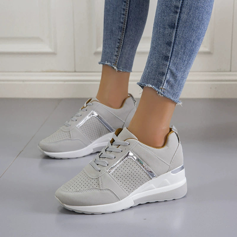 Pair of gray wedge sneakers worn with jeans