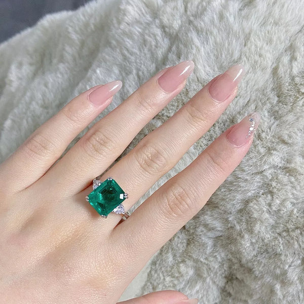 Green rectangular zircon ring displayed on a hand.