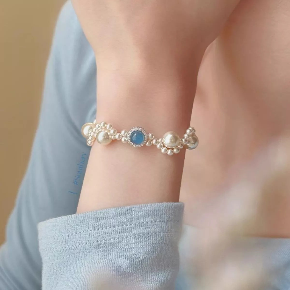 Pearl and blue-stone bracelet worn on a wrist