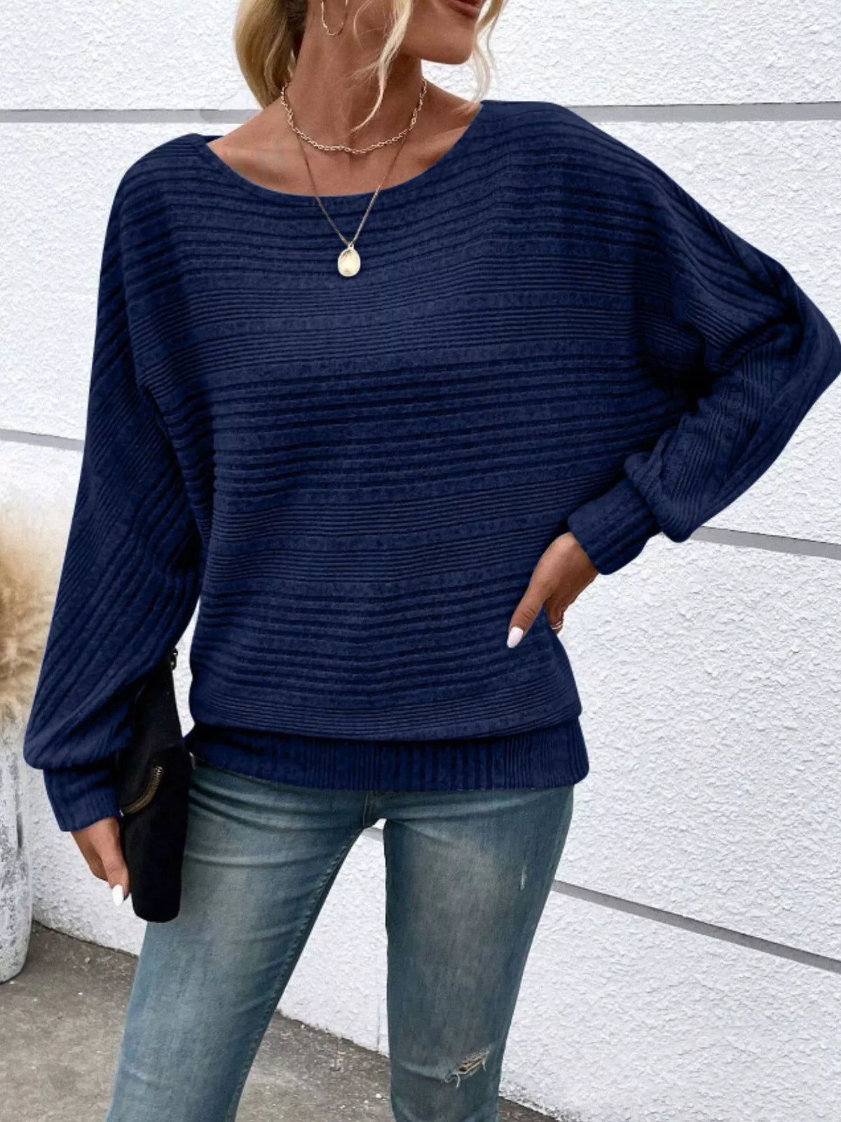 Women’s ribbed round-neck long-sleeve top in navy front view with hand at hip