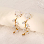 Pair of gold-tone flower drop earrings shown upright against a pale backdrop