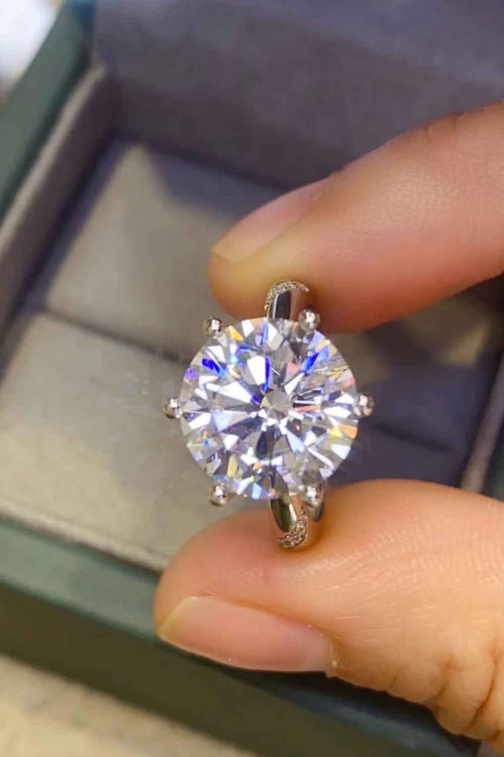 Front view of the round center stone held between fingertips.