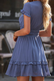 Side view of flutter sleeve and gathered waist on blue dress