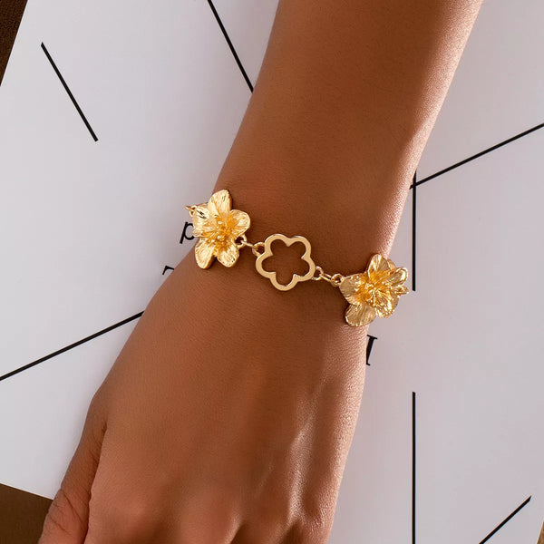 Gold-tone floral link bracelet worn on wrist