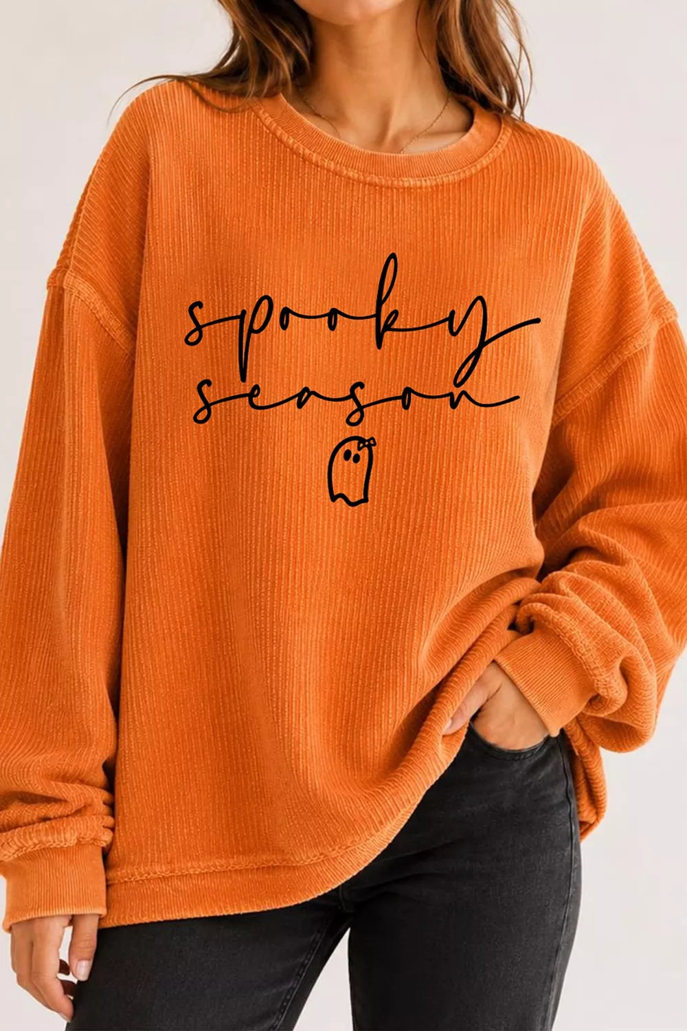 Orange ghost print pullover sweatshirt styled with black trousers