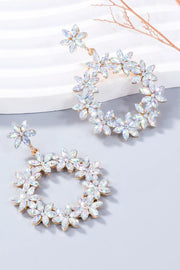 White rhinestone flower hoop dangle earring displayed on a white dish