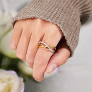 Gold-plated crisscross sterling silver ring worn on a hand