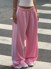 Pink wide-leg track pants with white side stripes, front view