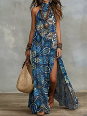 Women's printed sleeveless maxi dress in blue with a bold geometric pattern, shown full length with a side slit.