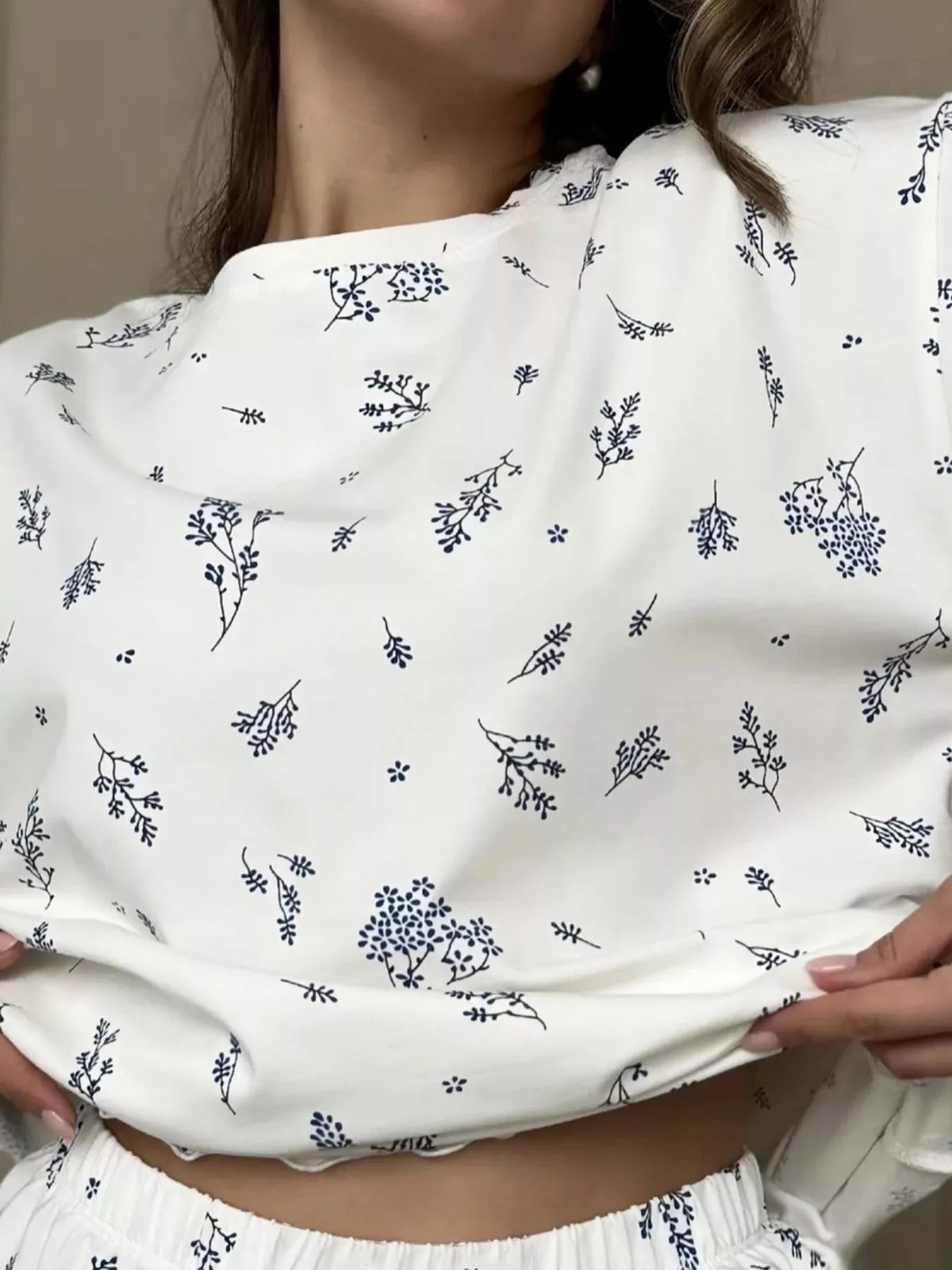 Close-up of white lounge top showing dark blue botanical sprig print