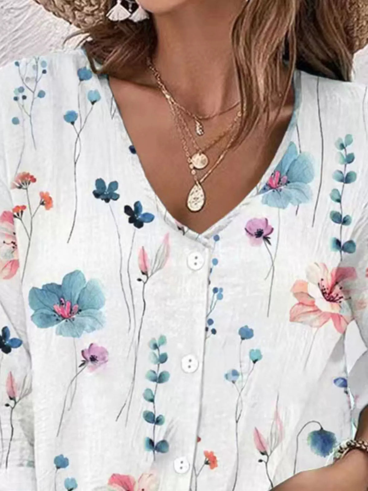 Close-up of white floral blouse neckline and button placket.