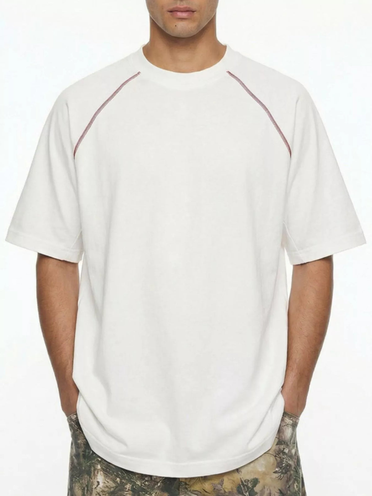 Model wearing white T-shirt with contrast shoulder piping