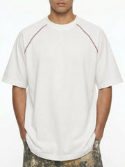 Model wearing white T-shirt with contrast shoulder piping