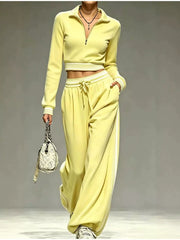 Model wearing yellow half-zip cropped top and wide-leg pants, full view