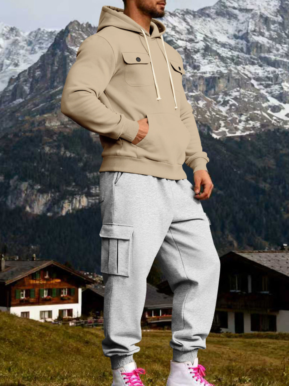 Three-quarter view of beige hoodie and grey cargo sweatpants with a hand in the front pouch