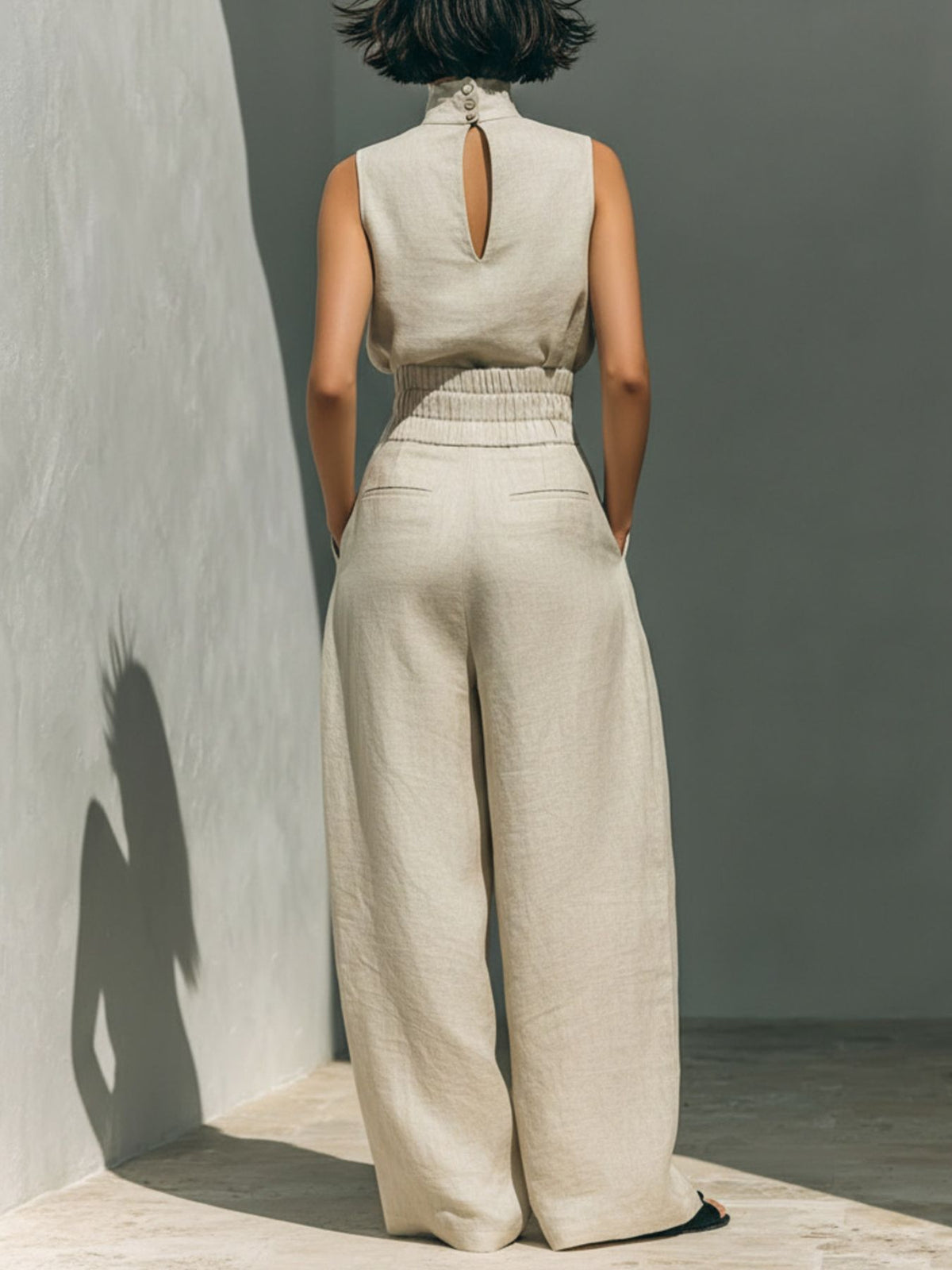 Back view of the cream turtleneck top and matching wide-leg trousers.