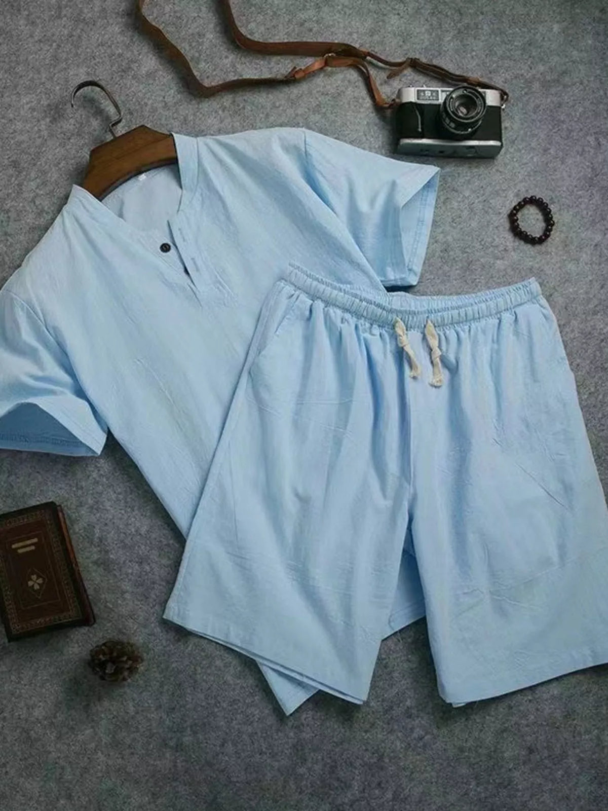 Light blue short-sleeve two-button shirt and matching drawstring shorts laid flat