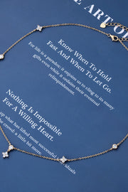 Silver-tone spaced-stone necklace displayed on a blue card