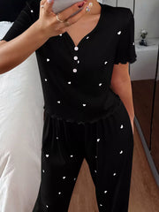 Close front view of black heart-print lounge top showing white buttons and lettuce-trim sleeves