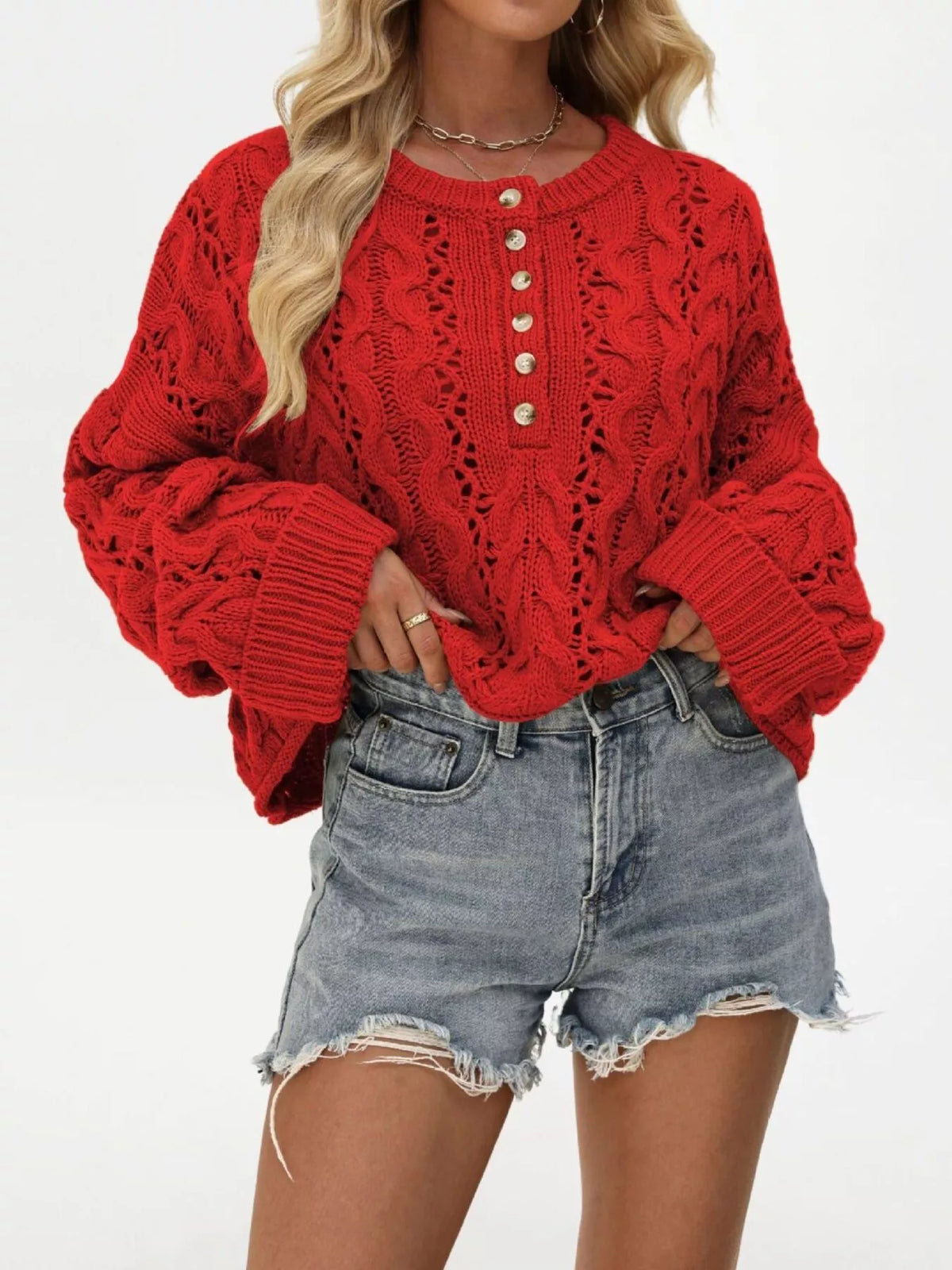 Women’s cable-knit half-button openwork sweater in red front pose with hand at hip
