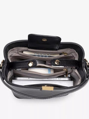 Overhead view into the black bucket bag, showing divided compartments and zip pockets.