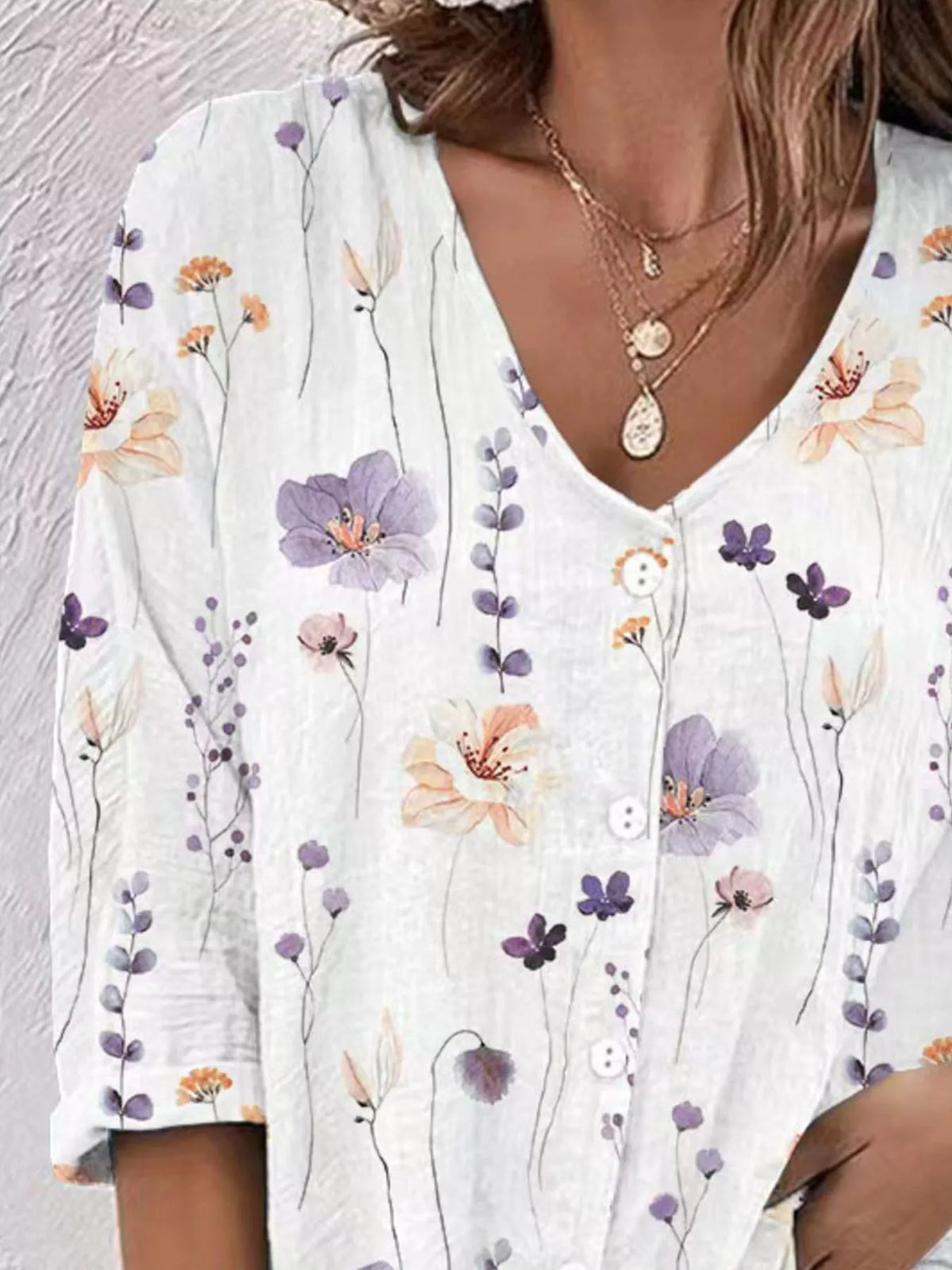 Detail view of white floral blouse front and buttons.